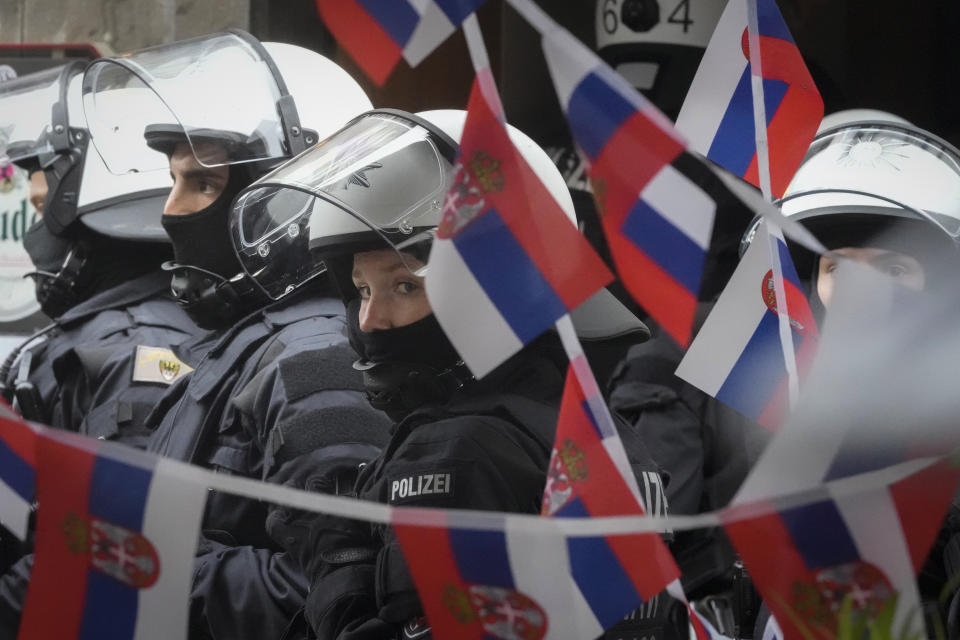 Police stand next to a restaurant decorated with Serbian flags ahead the Group C match between Serbia and England at the Euro 2024 soccer tournament in Gelsenkirchen, Germany, Sunday, June 16, 2024. (AP Photo/Markus Schreiber)