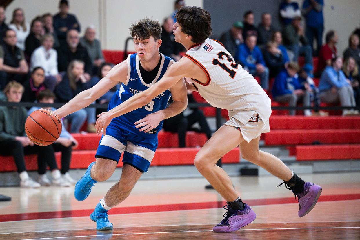 Hopedale's Patrick Madden drives and Maynard's DAniel Terrell defends during the Clark Tournament Small School Semifinal on Sunday February 18, 2024.
