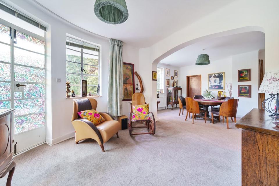 The living room is L-shaped, with curved windows overlooking the gardens (jdm Estate Agents)