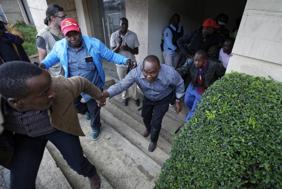 Civilians flee the scene at a hotel complex in Nairobi, Kenya Tuesday, Jan. 15, 2019. Terrorists attacked an upscale hotel complex in Kenya's capital Tuesday, sending people fleeing in panic as explosions and heavy gunfire reverberated through the neighborhood. (AP Photo/Ben Curtis)