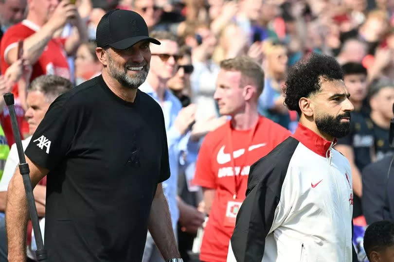 Liverpool's German manager Jurgen Klopp (L) walks out with Liverpool's Egyptian striker #11 Mohamed Salah (C) ahead of kick-off in the English Premier League football match between Liverpool and Wolverhampton Wanderers at Anfield in Liverpool, north west England on May 19, 2024. Jurgen Klopp said Friday he has experienced the "most intense" week of his life as he prepares to bring down the curtain on his trophy-filled Liverpool reign. Klopp, who arrived at the club in October 2015, won seven major trophies at Liverpool, including the club's first league title for 30 years and the 2019 Champions League. (Photo by Paul ELLIS / AFP) / RESTRICTED TO EDITORIAL USE. No use with unauthorized audio, video, data, fixture lists, club/league logos or 'live' services. Online in-match use limited to 120 images. An additional 40 images may be used in extra time. No video emulation. Social media in-match use limited to 120 images. An additional 40 images may be used in extra time. No use in betting publications, games or single club/league/player publications. /  (Photo by PAUL ELLIS/AFP via Getty Images)
