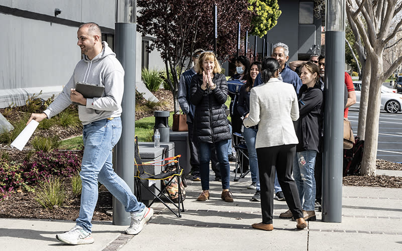 A waiting woman applauds another in the queue of customers seeking admittance to the collapsed Silicon Valley Bank