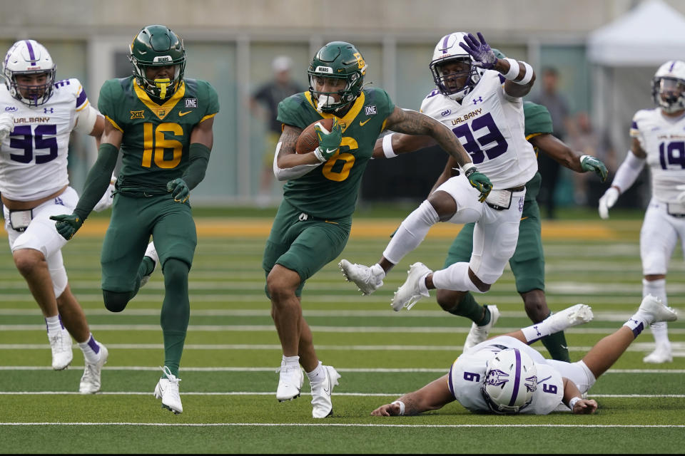 Baylor wide receiver Gavin Holmes (6) returns a punt for a touchdown in front of teammate Hal Presley (16) as Albany defenders Anthony Lang (9), Anton Juncaj (95) and Bill Hackett (33) pursue during the first half of an NCAA college football game in Waco, Texas, Saturday, Sept. 3, 2022. (AP Photo/LM Otero)