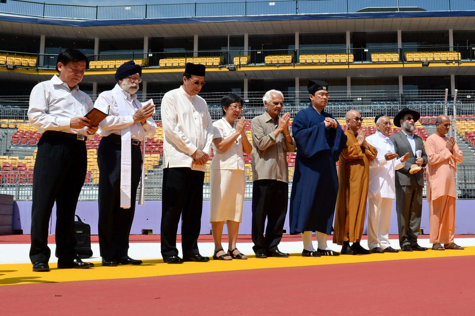 Representatives from Singapore's various religious groups saying a prayer ahead of the Formula One night race in September 2013. (PHOTO: AFP)