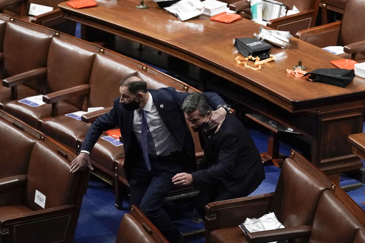 Lawmakers evacuate the floor as protesters try to break into the House Chamber at the U.S. Capitol on Wednesday, Jan. 6, 2021, in Washington.