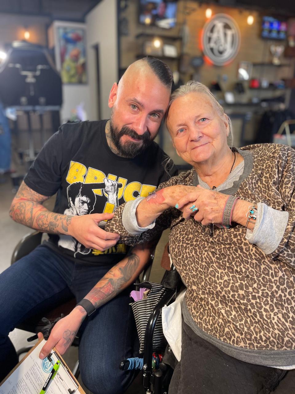 Body art practitioner Mike DeMasi of Art Junkies Tattoo Studio and GennaSue Longshore of Victorville, who celebrated her 80th birthday by getting her first tattoo.