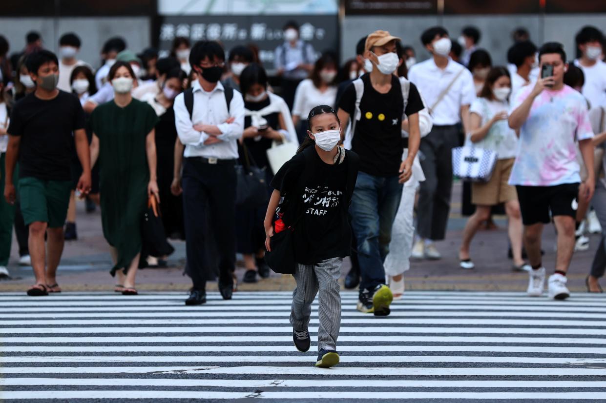 Pedestrians wearing protective masks amid the coronavirus disease (COVID-19) outbreak, walks on crosswalk in Tokyo (REUTERS)