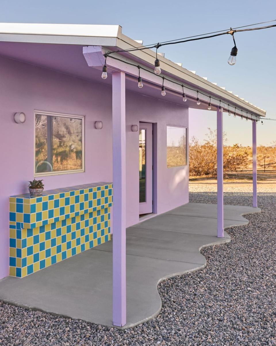 a purple house with a blue awning