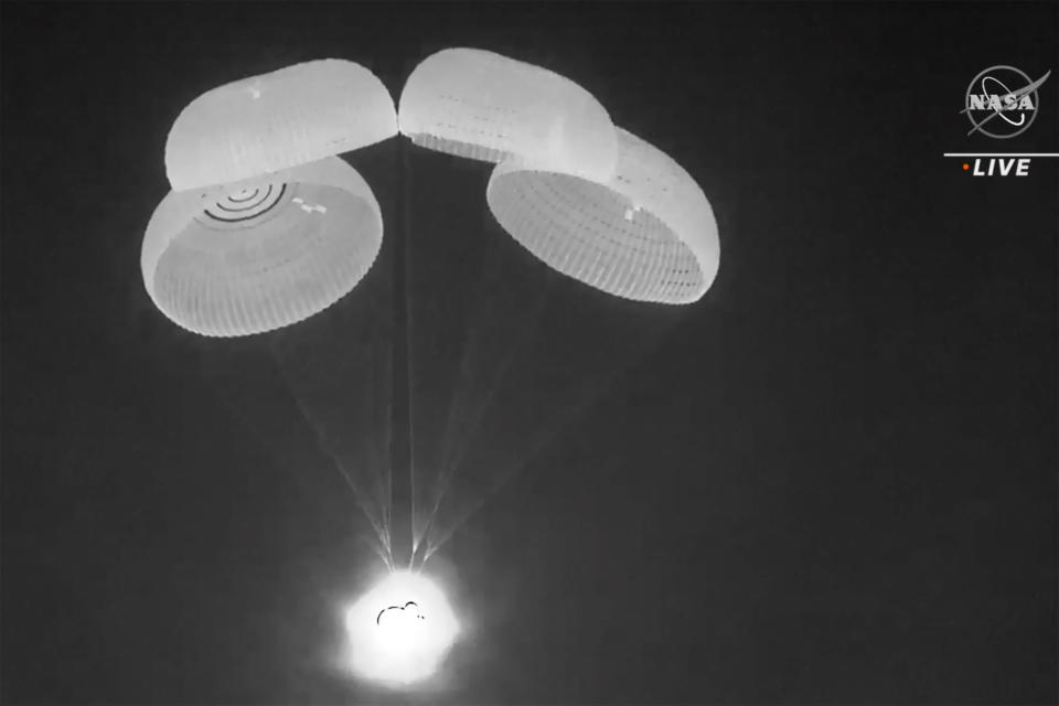 In this image made from video supplied by NASA, SpaceX Dragon capsule uses parachutes as it descends in the Gulf of Mexico early Friday, May 6, 2022. NASA’s Raja Chari, Tom Marshburn and Kayla Barron, and the European Space Agency’s Matthias Maurer undocked from the International Space Station less than 24 hours earlier. (NASA via AP)