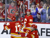 Calgary Flames forward Blake Colema (20) celebrates his goal against the Edmonton Oilers with Milan Lucic (17) and Rasmus Andersson (4) during the second period of Game 1 of an NHL hockey second-round playoff series Wednesday, May 18, 2022, in Calgary, Alberta. (Jeff McIntosh/The Canadian Press via AP)