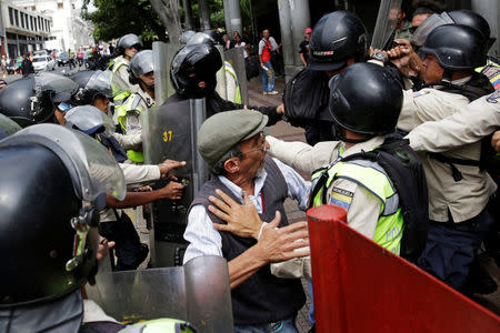 Pro-government supporters clash with riot police as opposition supporters protest against Venezuelan President Nicolas Maduro's government outside the courthouse in Caracas, Venezuela March 31, 2017. REUTERS/Marco Bello