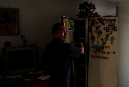 Businessmen Javier Esquives, 50, opens his fridge where he keeps his cool water as he explains how difficult it is to live without water, on the 9th floor of an apartment block in downtown in Caracas, Venezuela, March 19, 2019. REUTERS/Carlos Jasso