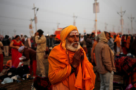 A devotee prays after taking a holy dip at Sangam, the confluence of the Ganges, Yamuna and Saraswati rivers, during "Kumbh Mela", or the Pitcher Festival, in Prayagraj, previously known as Allahabad, India, January 14, 2019. REUTERS/Danish Siddiqui