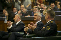 Kosovo president Hashim Thaci, center, Kosovo prime minister Ramush Haradinaj, left, and KSF Commander Lt. Gen. Rrahman Rama applaud after the Kosovo parliament approved the formation of an army in capital Pristina, Kosovo on Friday, Dec. 14, 2018. Kosovo's parliament convened on Friday to approve the formation of an army, a move that has angered Serbia which says it would threaten peace in the war-scarred region. (AP Photo/Visar Kryeziu)