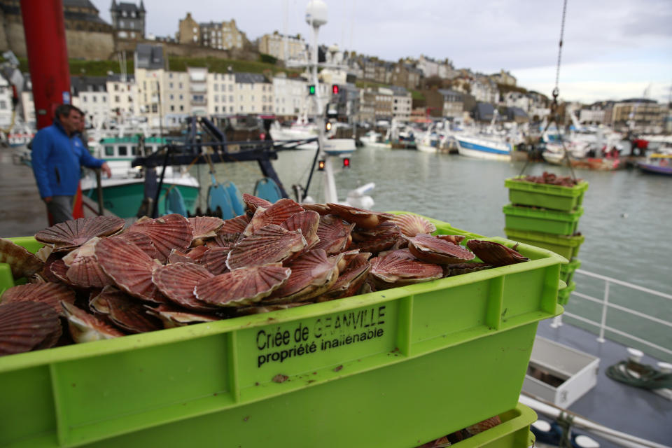 Boxes of scallops fished in the UK waters are pictured at the port of Granville, Normandy, Monday, Nov. 1, 2021. France has threatened to bar British boats from some of its ports and tighten checks on boats and trucks carrying British goods if more French vessels aren't licensed to fish in U.K. waters by Tuesday Oct.2, 2021. French fishing crews stood their ground, demanding a political solution to a local dispute that has become the latest battleground between Britain and the European Union. (AP Photo/Nicolas Garriga)