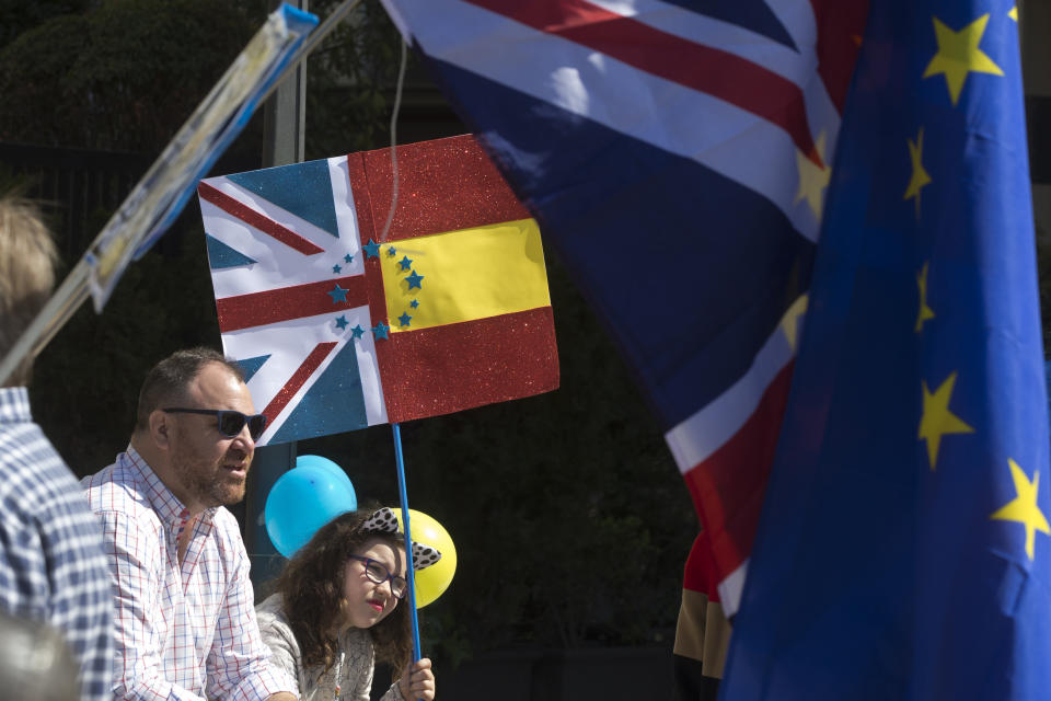 A young girl sits with a split British and Spanish flag during an anti Brexit protest in the Plaza Margaret Thatcher in Madrid, Spain, Saturday, March 23, 2019. Coinciding with the anti Brexit march in London, the Eurocitizens campaign group have organized a protest in the Spanish capital calling for the protection of British citizens living in Spain while asking for a second Brexit referendum. (AP Photo/Paul White)