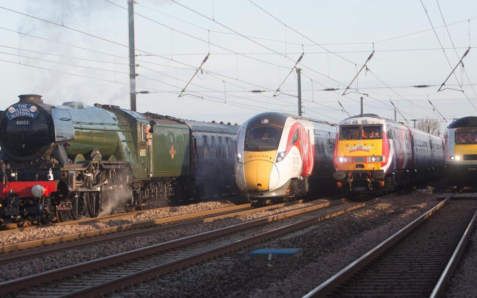 The Flying Scotsman and Virgin Trains' new Azuma travel in the same direction alongside two of the rail operator's present day fleet - to depict the past, present and future of UK rail travel, in a world first event, in the North Yorkshire countryside - Credit: PA