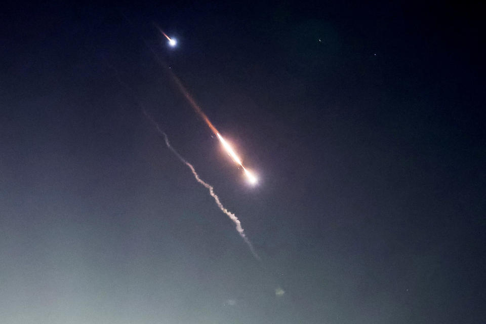 Objects are seen in the sky above Jerusalem after Iran launched drones and missiles towards Israel, in Jerusalem (Ronen Zvulun / Reuters)