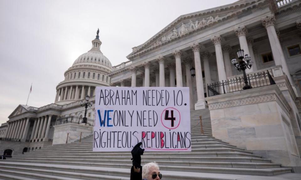 A protester holds a sign outside the impeachment trial on Thursday.