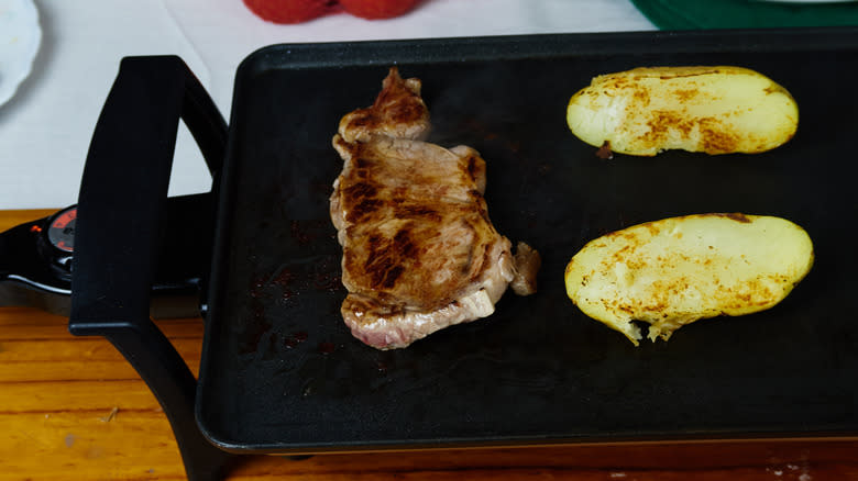 Meat and potatoes on electric griddle