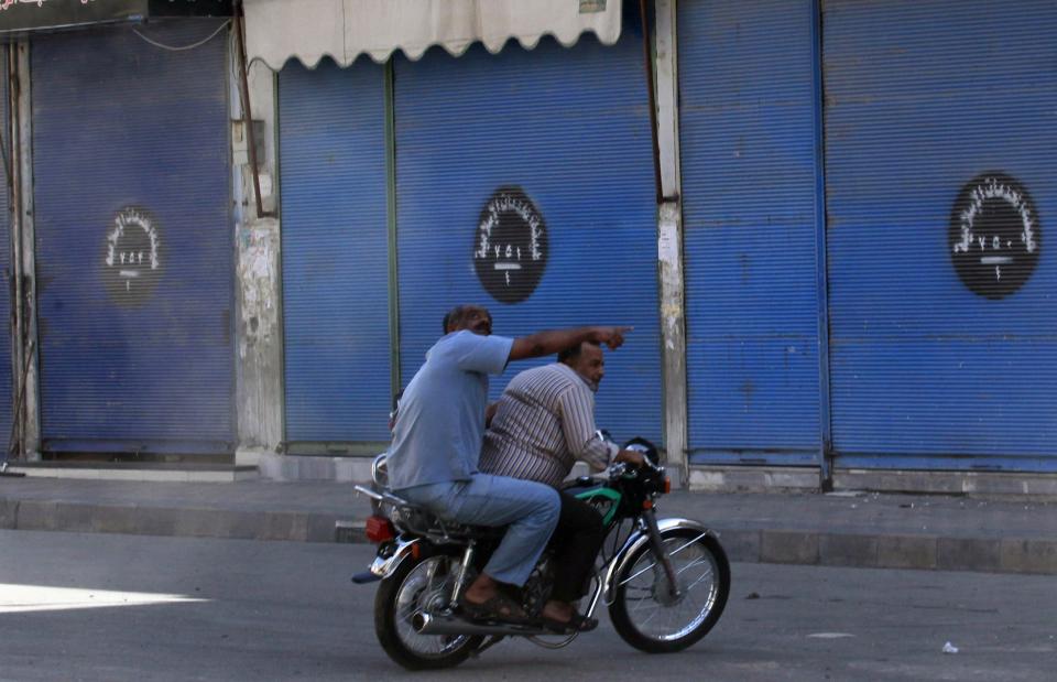 Residents flee what activists say was an air strike by forces loyal to Syria's President Assad on Tal Abyad street market in central Raqqa