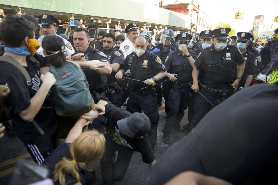 New York Police officers push back protesters during a demonstration Saturday, May 30, 2020, in the Brooklyn borough of New York. Protests were held throughout the city over the death of George Floyd, a black man who was in police custody in Minneapolis. Floyd died after being restrained by Minneapolis police officers on Memorial Day. (AP Photo/Seth Wenig)