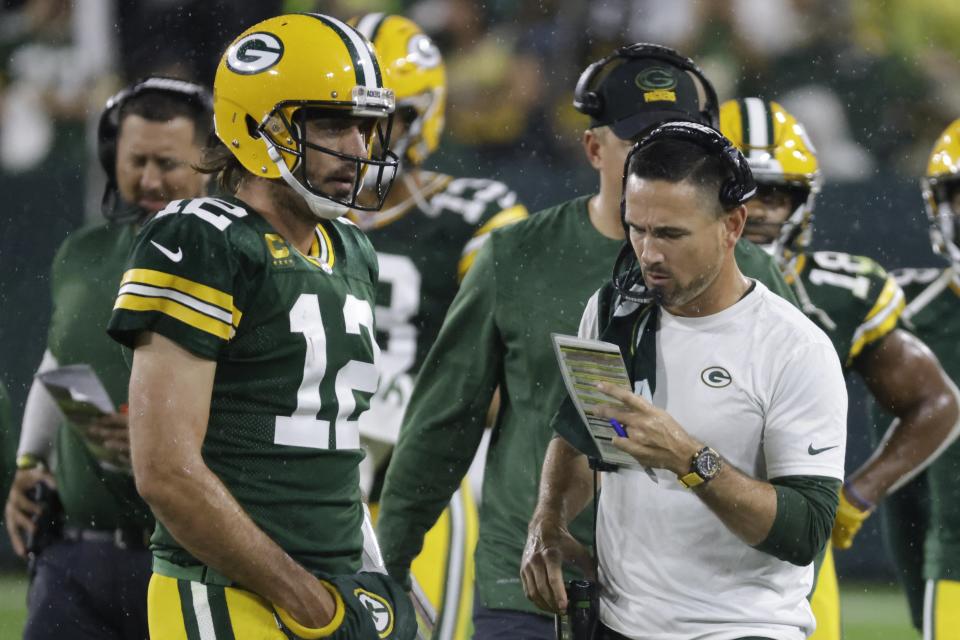 Green Bay Packers head coach Matt LaFleur talks to Aaron Rodgers during the second half of an NFL football game against the Detroit Lions Monday, Sept. 20, 2021, in Green Bay, Wis. (AP Photo/Mike Roemer)