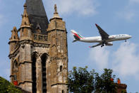 FILE PHOTO: A commercial airliner flies over the 14th century Saint-Pierre-et-Saint-Paul Church, which is classified as an historic monument, in Goussainville-Vieux Pays, 20 kms (12 miles) north of Paris, August 28, 2013. REUTERS/Charles Platiau/File Photo