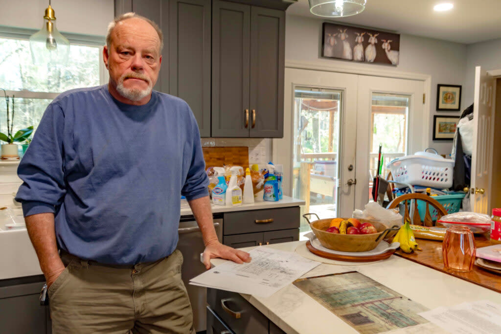 A man standing in a kitchen with a map