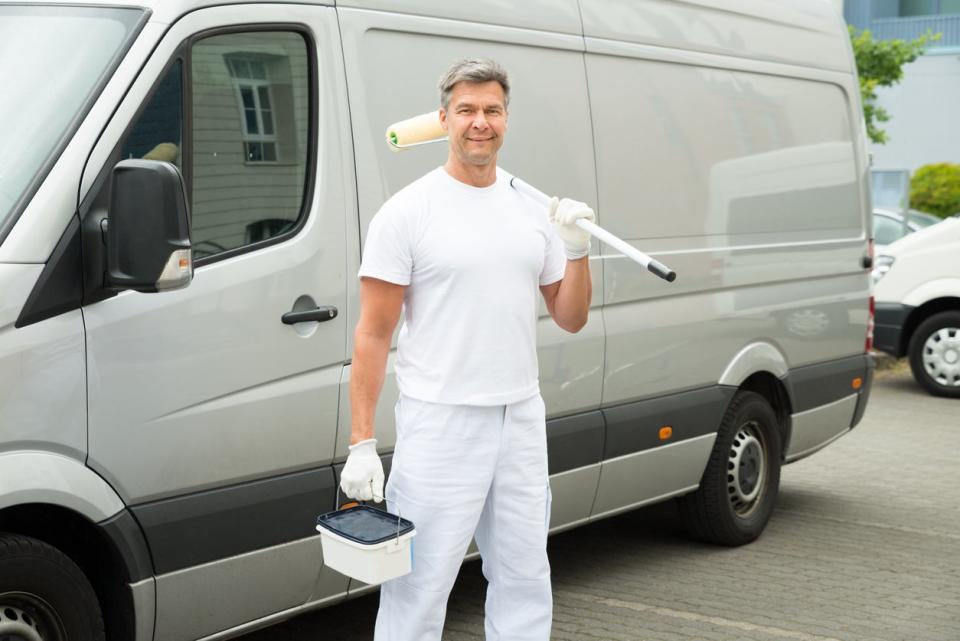  Painter Standing In Front Of Van holding painting gear