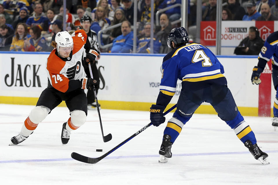 Philadelphia Flyers' Owen Tippett (74) controls the puck under pressure from St. Louis Blues' Nick Leddy (4) during the third period of an NHL hockey game Monday, Jan. 15, 2024, in St. Louis. (AP Photo/Scott Kane)