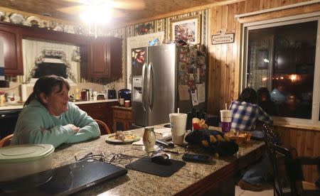 Brenda Manley (L), watches local news reports about a crude oil train fire as her husband, Dane (R), watches the train burn through a kitchen window in Boomer, West Virginia February 16, 2015. REUTERS/Marcus Constantino