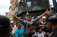 A Honduran migrant, part of a caravan trying to reach the U.S., argues with police officers near the border with Mexico, in Tecun Uman, Guatemala October 19, 2018. REUTERS/Edgard Garrido