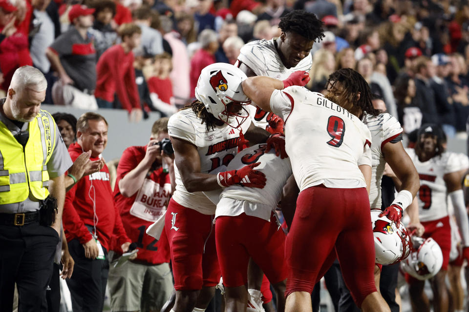 Louisville players celebrate an interception by Quincy Riley (3) against North Carolina State during the second half of an NCAA college football game in Raleigh, N.C., Friday, Sept. 29, 2023. (AP Photo/Karl B DeBlaker)