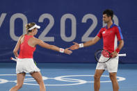 Nina Sojanovic, left, and Novak Djokovic, of Serbia, high five during a first round mixed doubles tennis match against Luisa Stefani and Marcelo Melo, of Brazil, at the 2020 Summer Olympics, Wednesday, July 28, 2021, in Tokyo, Japan. (AP Photo/Patrick Semansky)