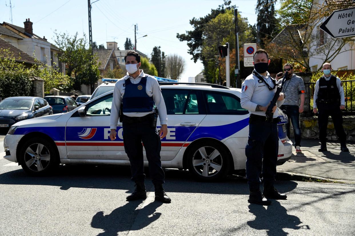 <p>French police officials close a street near a police station in Rambouillet after the fatal stabbing</p> (AFP/Getty)