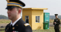 A Vietnamese soldier, center, stands guard near U.S. soldiers at the dioxin contaminated area when U.S. Secretary of Defense Jim Mattis, unseen, visited Bien Hoa airbase, where the U.S. army stored the defoliant Agent Orange during the Vietnam War, in Bien Hoa city, outside Ho Chi Minh city, Vietnam, Wednesday, Oct. 17, 2018. (Kham/Pool Photo via AP)