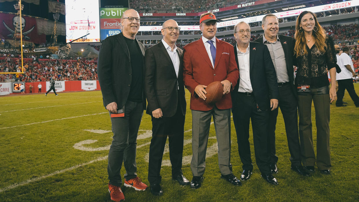Former Tampa Bay Buccaneers head coach Jon Gruden, center, poses with Glazer family members, owners of the team, after being inducted into the Buccaneers Ring of Honor during halftime of an NFL football game against the Atlanta Falcons, in Tampa, FlaFalcons Buccaneers Football, Tampa, USA - 18 Dec 2017.