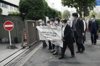 Plaintiffs and their supporters arrive at the Tokyo District Court Thursday, Oct. 14, 2021, in Tokyo. The court is hearing five ethnic Korean residents of Japan and a Japanese national demanding the North Korean government pay compensation over their human rights abuses in that country after joining a resettlement program there that promised a “paradise on Earth,” but without the presence of a defendant - the North’s leader. The banner on top reads: "Oct. 14 Tokyo District Court the North Korea "Paradise on Earth" campaign first trial. (AP Photo/Eugene Hoshiko)