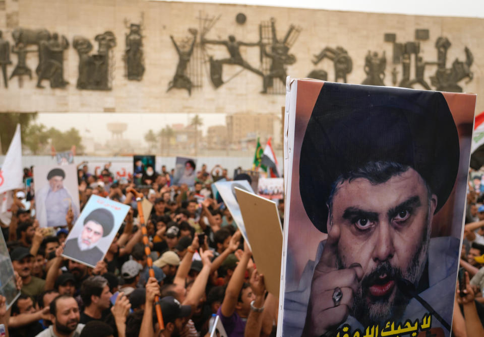 Followers of Shiite cleric Muqtada al-Sadr hold posters with his photo as they celebrate the passing of a law criminalizing the normalization of ties with Israel, in Tahrir Square, Baghdad, Iraq, Thursday, May 26, 2022. (AP Photo/Hadi Mizban)