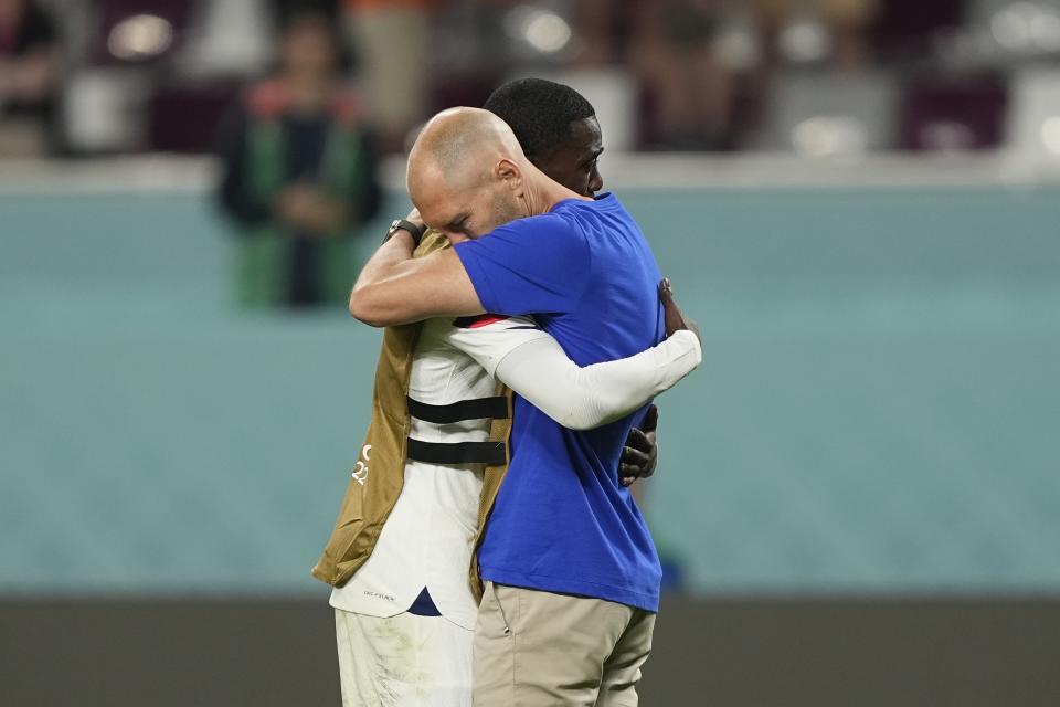 Head coach Gregg Berhalter of the United States, right, hugs his player Tim Weah after the World Cup round of 16 soccer match between the Netherlands and the United States, at the Khalifa International Stadium in Doha, Qatar, Saturday, Dec. 3, 2022. The Netherlands won 3-1. (AP Photo/Martin Meissner)