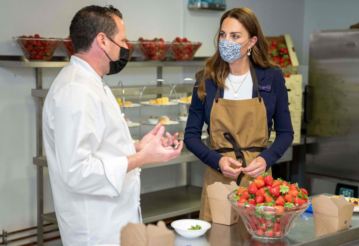 Britain's Catherine, Duchess of Cambridge, Patron of the All England Lawn Tennis Club, talks with with chef Adam Fargin as she prepares strawberries in the Wingfield kitchen during her visit on the fifth day of the 2021 Wimbledon Championships at The All England Tennis Club in Wimbledon, southwest London, on July 2, 2021. - RESTRICTED TO EDITORIAL USE (Photo by AELTC/Thomas Lovelock / POOL / AFP) / RESTRICTED TO EDITORIAL USE (Photo by AELTC/THOMAS LOVELOCK/POOL/AFP via Getty Images)