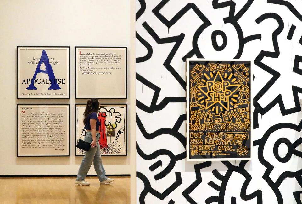 A museum guest takes in a series titled "Apocalypse," a collaboration by Haring and William Burroughs in the "Keith Haring: Against All Odds" exhibit at the Akron Art Museum, Wednesday, May 17, 2023, in Akron, Ohio.