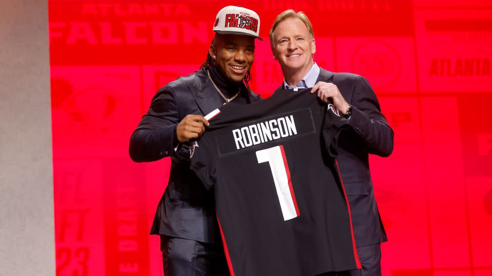Bijan Robinson poses with NFL Commissioner Roger Goodell after being selected eighth overall by the Atlanta Falcons. - David Eulitt/Getty Images