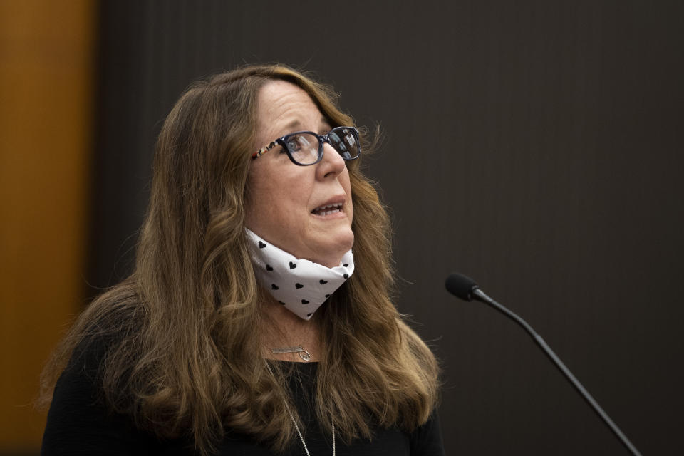 Sandy James looks up from the podium as she makes her statement with Joseph James DeAngelo, known as the Golden State Killer, in the courtroom during the first day of victim impact statements Tuesday, Aug. 18, 2020, in Sacramento, Calif. DeAngelo will be formally sentenced to life in prison Friday. (Santiago Mejia/San Francisco Chronicle via AP, Pool)