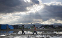 <p>Two boys walk past a pond at the migrant camp in Idomeni, Greece, May 22, 2016. Thousands of stranded refugees and migrants have camped in Idomeni for months after the border was closed. (Darko Bandic/AP) </p>