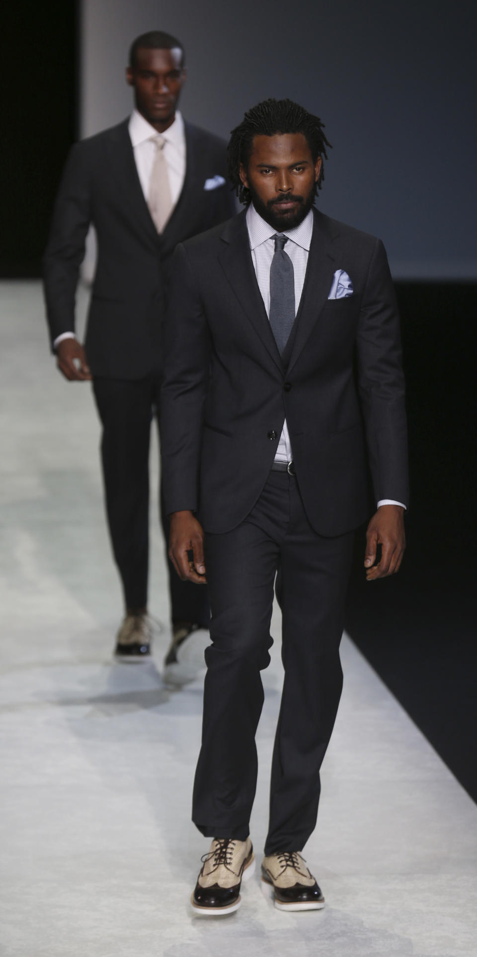 Models wear creations for Giorgio Armani men's Spring-Summer 2014 collection, part of the Milan Fashion Week, unveiled in Milan, Italy, Tuesday, June 25, 2013. (AP Photo/Luca Bruno)