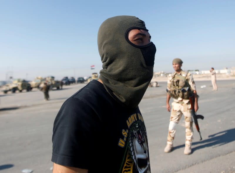 A member of Iraqi army forces guards at the entrance of Umm Qasr Port as protesters block the road during ongoing anti-government protests in south of Basra