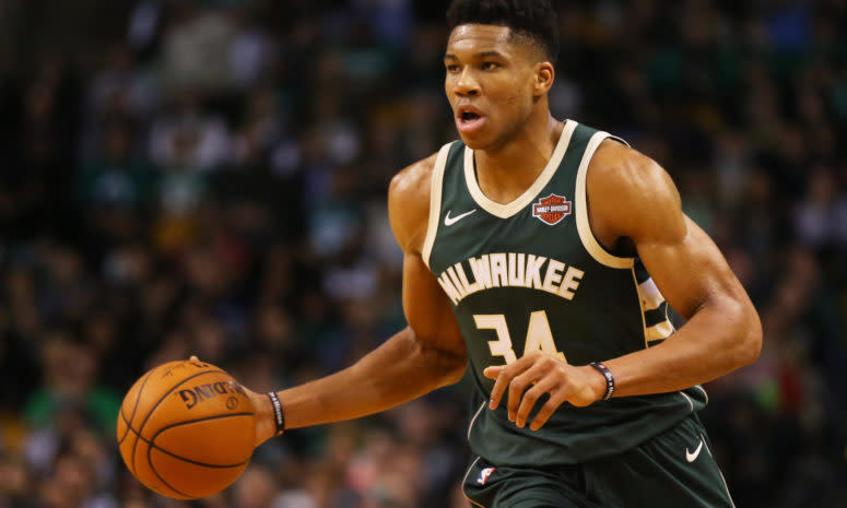 A closeup of Giannis Antetokounmpo dribbling the ball.