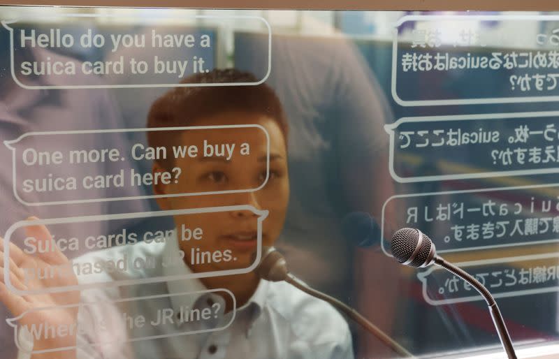 A staff of Seibu Railway uses an automated translation window to communicate with a Austrian tourist at the Seibu-Shinjuku station in Tokyo